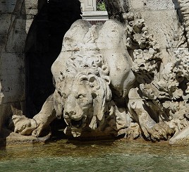 From a shady den, carved here, as well,
A thirsty Lion comes out,
Standing on the stones, keeping its body still,
Flexing its shoulders and further lowering its neck.
Its dry tongue, coming out of its mouth,
Cannot reach the water level, and so
It stretches as much as it can, yet not enough,
It barely touches the water, it barely drinks.